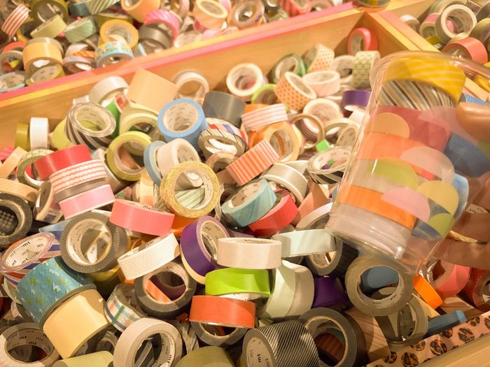 Cientos de rollos de cinta washi de colores pastel y estampados en una caja de madera
